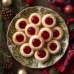 Classic thumbprint cookies filled with red and green jam on a festive holiday plate