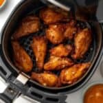 Golden crispy chicken wings in an air fryer basket.