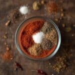 Spiced ground beef cooking in a skillet, seasoned with a vibrant red homemade spice blend.