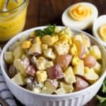 Close-up of deviled egg salad with chopped eggs and mustard dressing in a white bowl