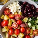Bowl of Greek potato salad with olives, herbs, and lemon dressing