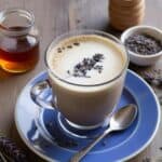 Overhead shot of a lavender honey iced latte with straw and fresh lavender flowers
