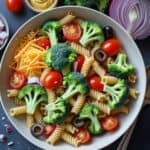 Close-up of healthy broccoli pasta salad with cheddar cheese and red onions