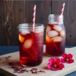 Glass of refreshing hibiscus iced tea with ice and a lemon slice