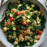 Bowl of fresh kale quinoa salad with cherry tomatoes and lemon dressing