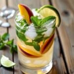Refreshing peach mojito in a tall glass with crushed ice and fresh mint leaves