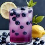 Glass of refreshing blueberry lemonade with lemon slices and blueberries