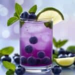 Close-up of blueberry mojito cocktail with ice and mint garnish