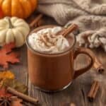 mug of creamy pumpkin spice hot chocolate topped with whipped cream and cinnamon
