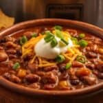 Bowl of hearty slow cooker chili topped with cheese and sour cream